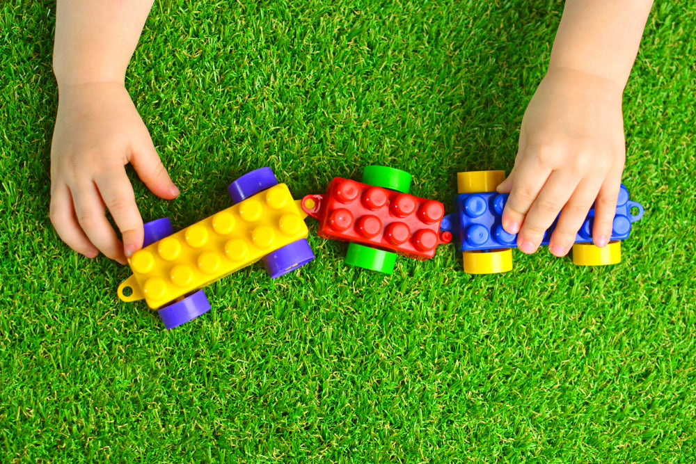 Kid Playing With Train On Artificial Grass